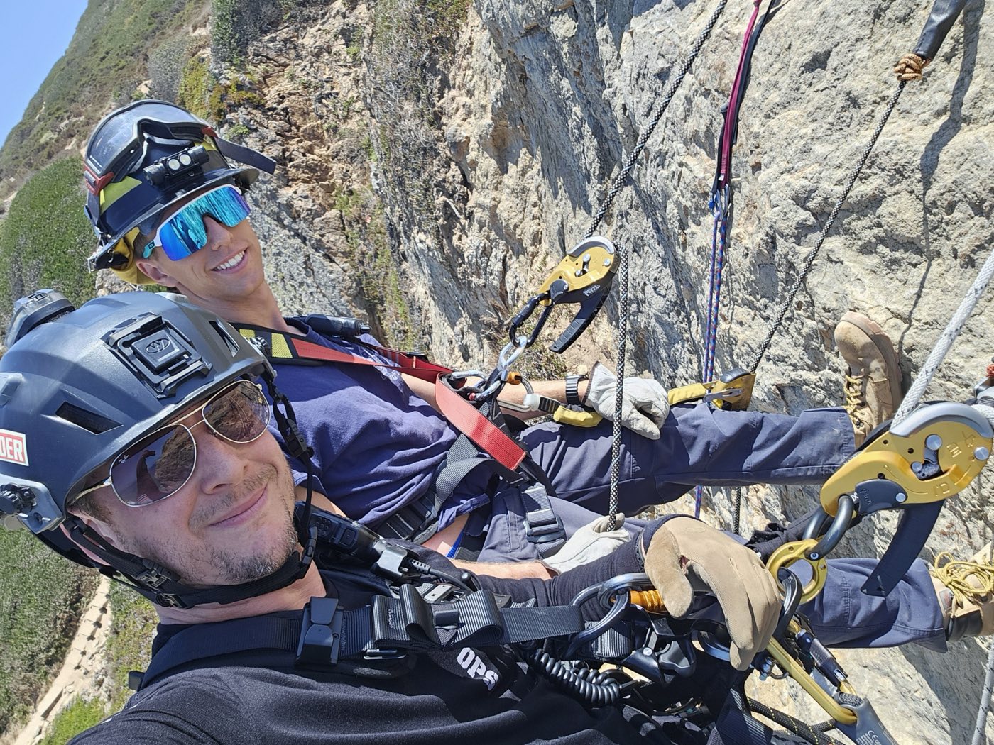 SAR OPS members rappelling on a coastal cliff